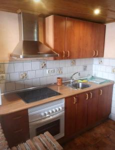 a kitchen with a sink and a stove top oven at Casita El Granero in Iznatoraf