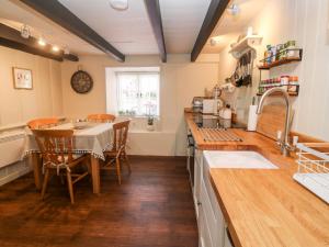 a kitchen with a table and a dining room at Penhale Cottage in Marazion