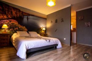 1 dormitorio con 1 cama y una pared con una pintura en Les escargots du mont en Tanis