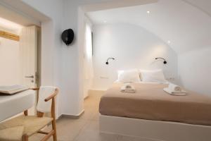 a bedroom with a bed and a desk and a chair at Melidron Hotel & Suites in Agios Prokopios