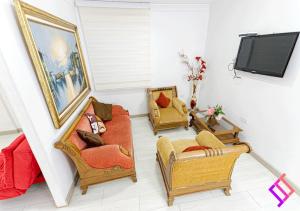 uma sala de estar com duas cadeiras e uma televisão em Apartamento Moderno en la Ciudad Vallenata em Valledupar