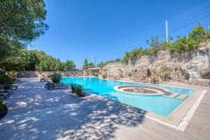 una piscina en un complejo con una pared de roca en AEGEAN Apartments - Çeşme en Cesme