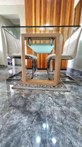 a glass table and chairs in a room at Affordable Hyswan Family Guesthouse in Krugersdorp