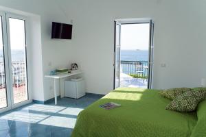 a bedroom with a bed and a balcony with the ocean at Punta Lingua Relais - Room 2 Sunset Terrace in Procida