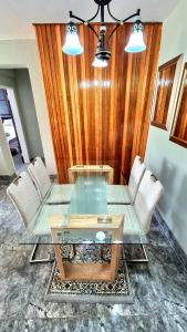 a dining room with a glass table and chairs at Affordable Hyswan Family Guesthouse in Krugersdorp