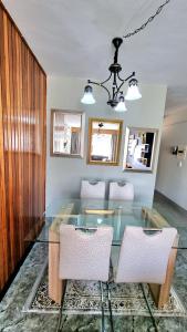クルーガーズドープにあるAffordable Hyswan Family Guesthouseのダイニングルーム(ガラスのテーブル、椅子付)