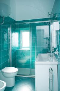 uma casa de banho azul com um WC e um lavatório em Punta Lingua Relais - Room 2 Sunset Terrace em Procida