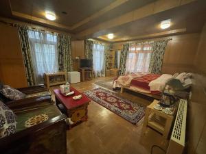 een slaapkamer met een bed en een woonkamer bij Hotel Ladakh Greens in Leh