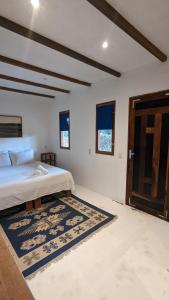 a bedroom with a bed and a door and a rug at Pousada Eureka in Atins