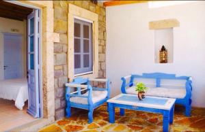a room with blue chairs and a table and a bed at Apanemo in Grikos