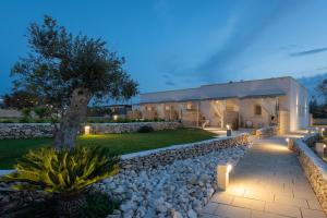 una casa con un sentiero in pietra e luci nel cortile di Tenuta Puloni a Otranto