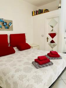 a bedroom with a bed with red pillows on it at Casa M&M in Cala Gonone