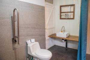 a bathroom with a toilet and a sink at Roots Family in Puerto Viejo