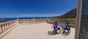 a balcony with a table and chairs and the ocean at Pomos Harbourbiew Villa in Pomos