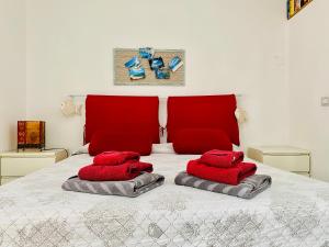 a bedroom with red pillows on a white bed at Casa M&M in Cala Gonone