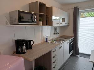 una pequeña cocina con fregadero y microondas en Ferienhaus am Binnenhafen, en Emden