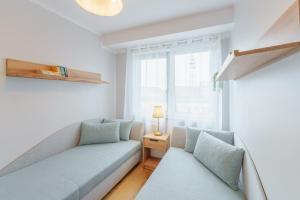 ein Wohnzimmer mit einem Sofa und einem Fenster in der Unterkunft Apartament Doro in Kołobrzeg