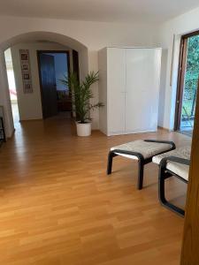 a living room with a wooden floor and a table and bench at Ferienwohnung Dorfperle in Bad Mergentheim +9 photos