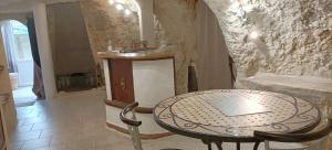 Habitación con mesa y pared de piedra. en Cave du Coteau 2, en Lunay