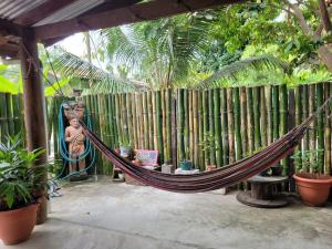een hangmat in een tuin met een hek bij Roots Family in Puerto Viejo