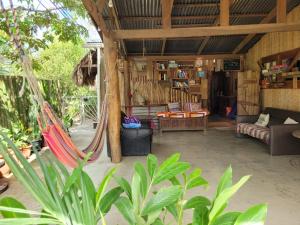 una sala de estar con hamacas en una casa en Roots Family, en Puerto Viejo