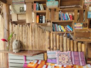a room with wooden bookshelves and a bench with books at Roots Family in Puerto Viejo