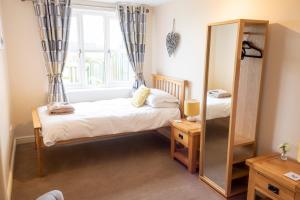 una camera con 2 letti singoli e uno specchio di Grange Farm Cottages a Wressell