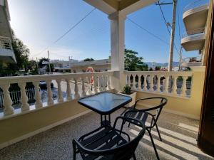 a table and two chairs on a balcony at Hall Apartments & Rooms - by Avelink in Spata