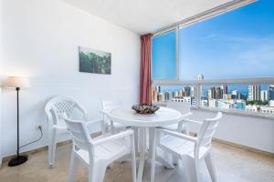 ベニドルムにあるGemelos 22 Resort Apartment 3-18-B Levante Beachの窓付きの客室で、白いテーブルと椅子が備わります。