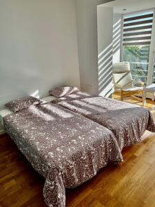 1 dormitorio con 1 cama, 1 silla y 1 ventana en Vilniaus 96 apartments en Ukmergė