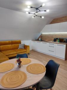 een woonkamer met een tafel en een keuken bij Westa Apartamenty in Krynica Zdrój