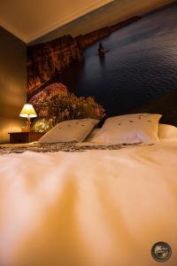 een bed met 2 kussens in een slaapkamer met een muur bij Les escargots du mont in Tanis