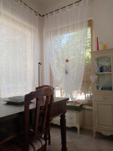 a kitchen with a table and a window with curtains at La Serra in Murlo +21 photos
