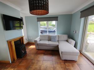 sala de estar con sofá y chimenea en Lislary Cottage on Wild Atlantic Way en Sligo