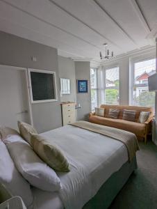 um quarto com uma cama grande e um sofá em Redlands em Brixham