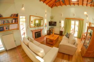 a living room with a white couch and a fireplace at Artemis House in Agios Georgios Pagon