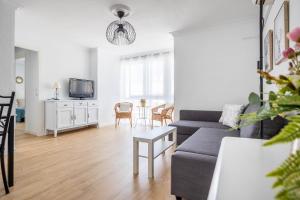 salon z kanapą i stołem w obiekcie Apartamento Isbilya w Sewilli