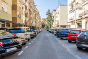 rząd samochodów zaparkowanych na poboczu ulicy w obiekcie Apartamento Isbilya w Sewilli