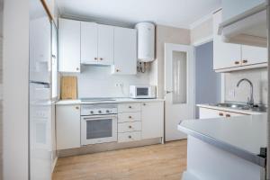 biała kuchnia z białymi szafkami i zlewem w obiekcie Apartamento Isbilya w Sewilli +20 zdjęć