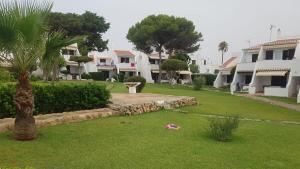 a view of a yard with houses and palm trees at Apartamento Bellavista in Cala en Bosc