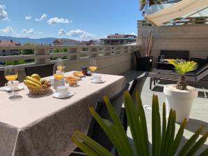 einen Tisch mit Essen und Weingläsern auf dem Balkon in der Unterkunft CANELAS SUITES ÁTICO Amplias Terrazas in Sanxenxo