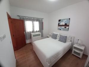 um quarto com uma cama branca e uma janela em Estudio SERMAR em Punta Mujeres