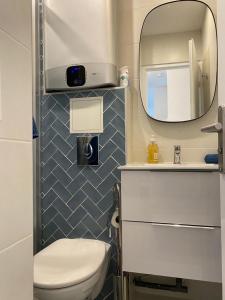 a bathroom with a white toilet and a mirror at Superbe appartement style architecte/unique** in Nice