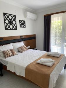 a bedroom with a large bed with two towels on it at Hanlı Apart Otel in Muğla