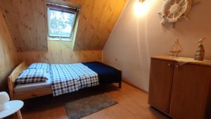 a small bedroom with a bed and a window at Nad Miedwinką - Dom in Morzyczyn