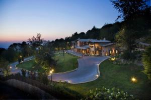 a large house with a driveway in a yard at Chalet Euthalia Restaurant & Suites in San Giacomo