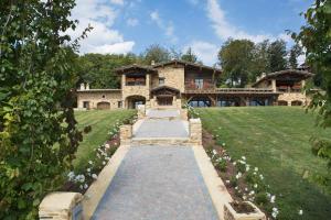 a stone house with a pathway in front of it at Chalet Euthalia Restaurant & Suites in San Giacomo