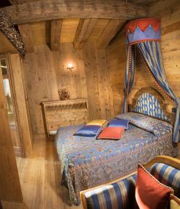 a bedroom with a bed in a log cabin at Chalet Euthalia Restaurant & Suites in San Giacomo