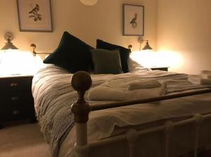 a bedroom with a bed with two lights on it at Lavender Cottage in Mattishall