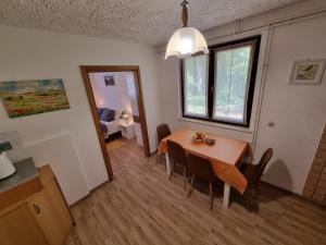 a dining room with a table and chairs and a bedroom at TOMLJANOVIĆ in Plitvička Jezera